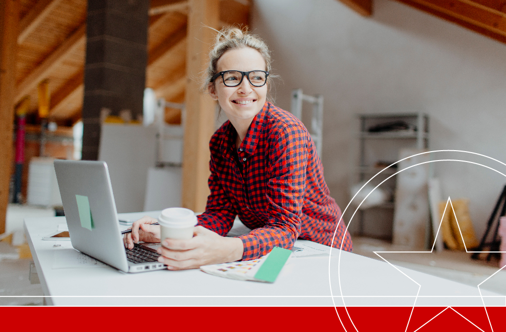 Woman smiling working on a laptop at home