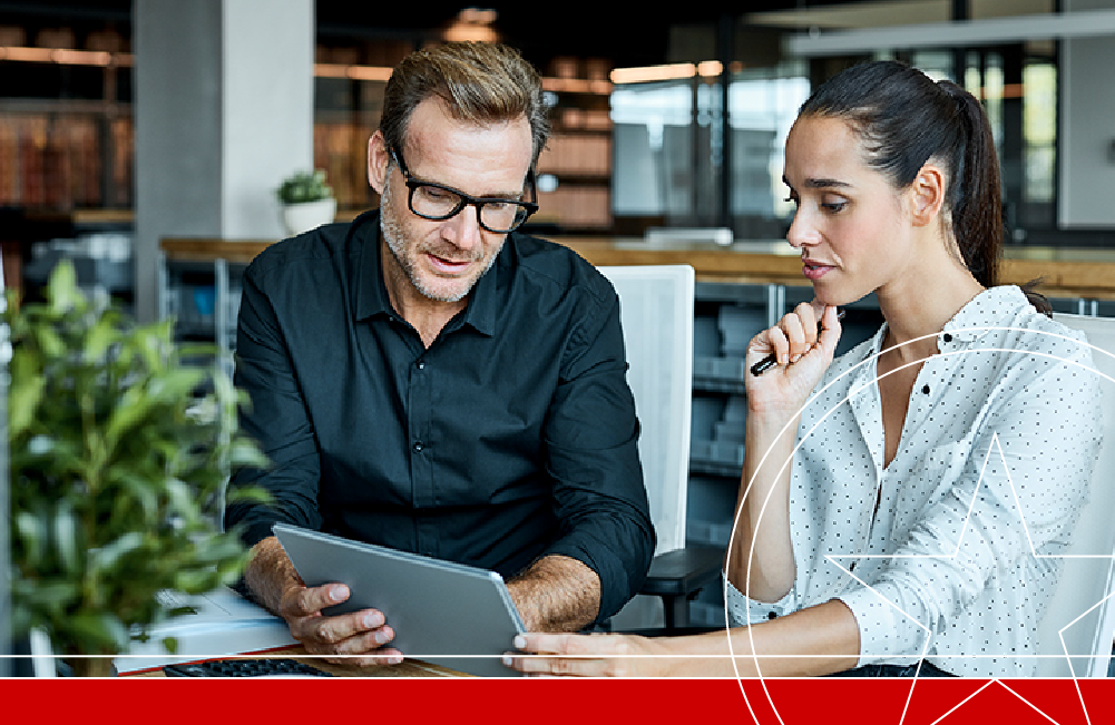 Man and Woman in office looking at tablet