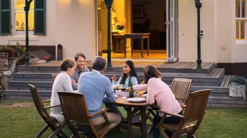 Family looking eating at table outside