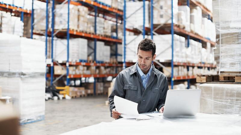 Man looking at paper in warehouse