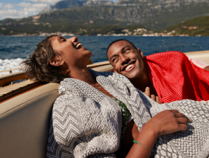Young man and woman laughing in speedboat