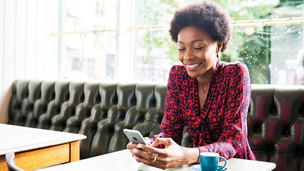 woman on her phone sitting on a couch