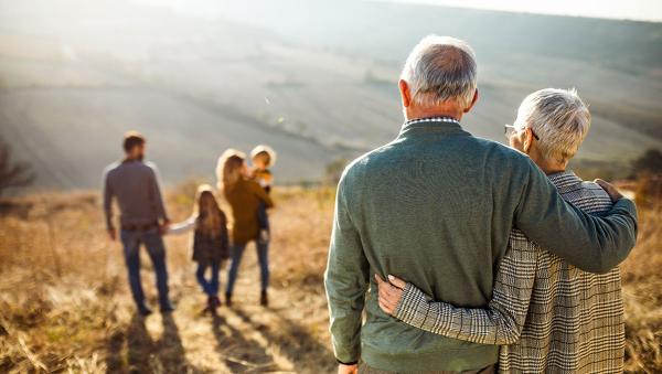 Older couple standing in the background behind a man, woman, and two children