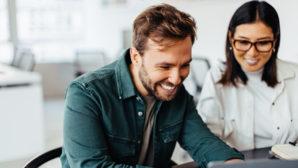 man and woman looking at a computer and smiling