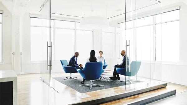 Four coworkers sitting in a conference room meeting